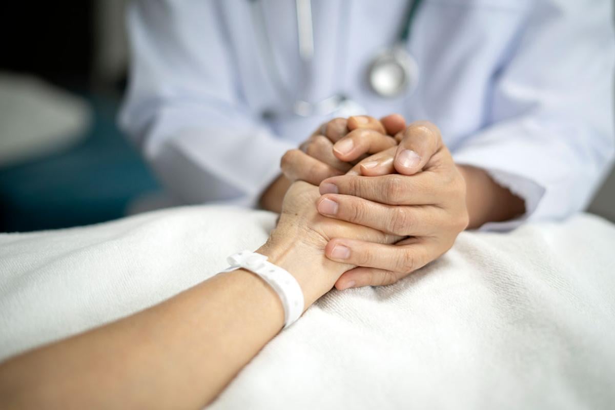 Physician holding patient's hand
