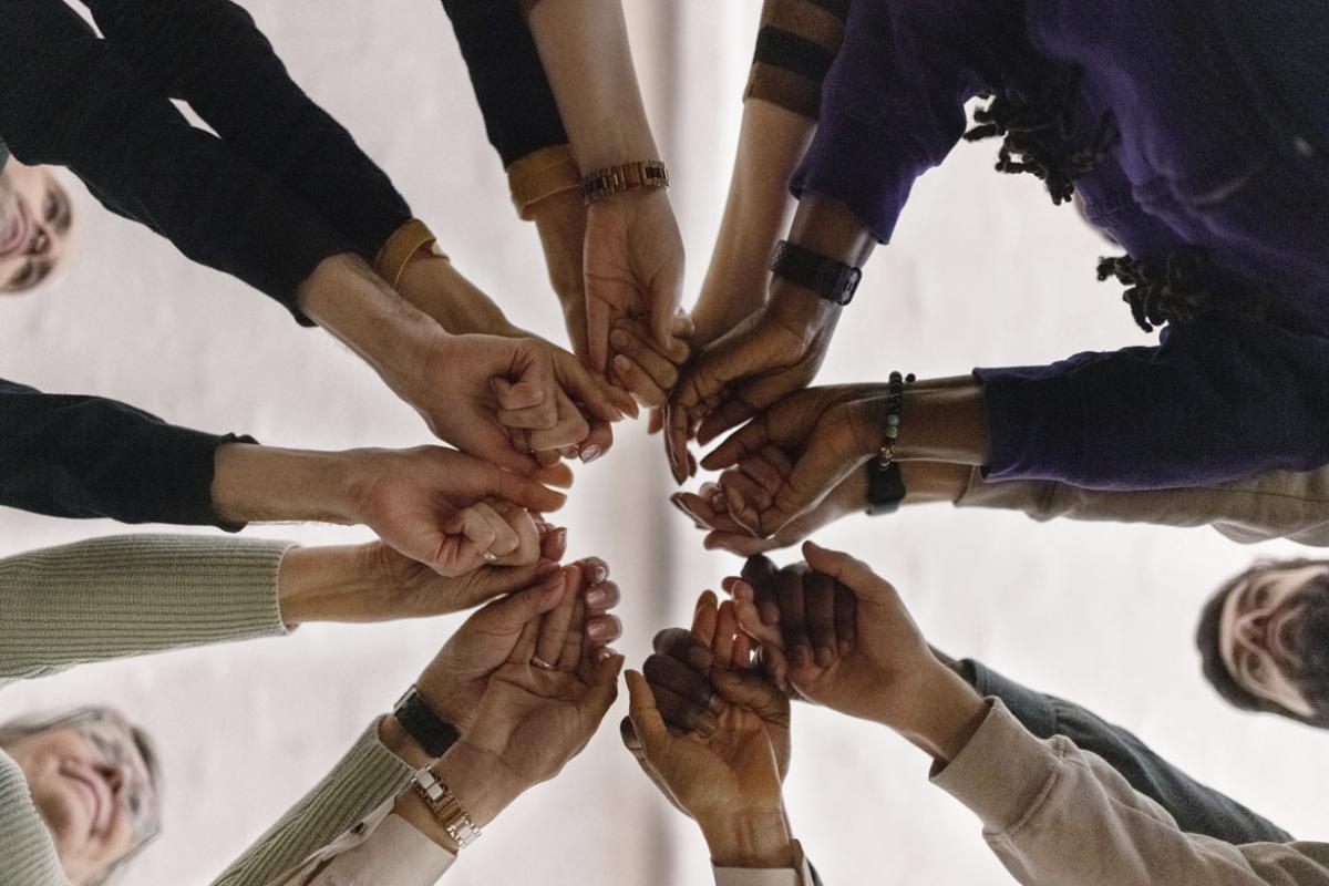 Group of people in circle holding their fists together