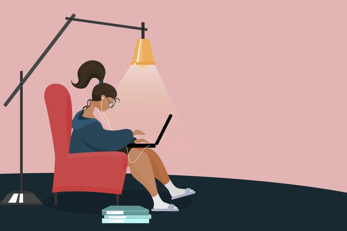 Figure sitting on an armchair while studying via a laptop